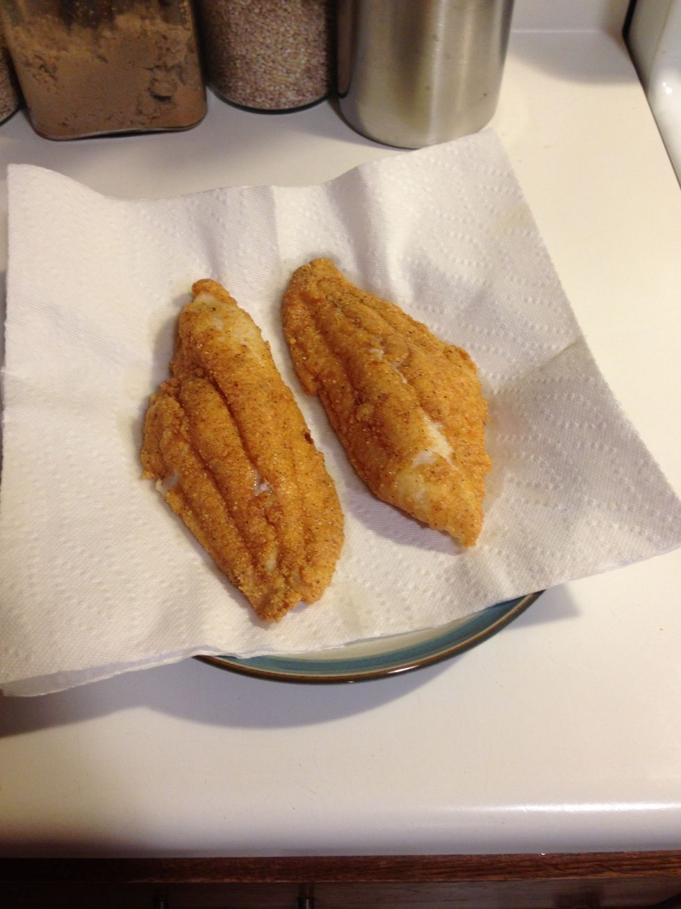 Place on a plate lined with paper towels for at least a minute. The fish will stay hot, and the excess oil will drain off. The fish should flake away easily with a fork when done.