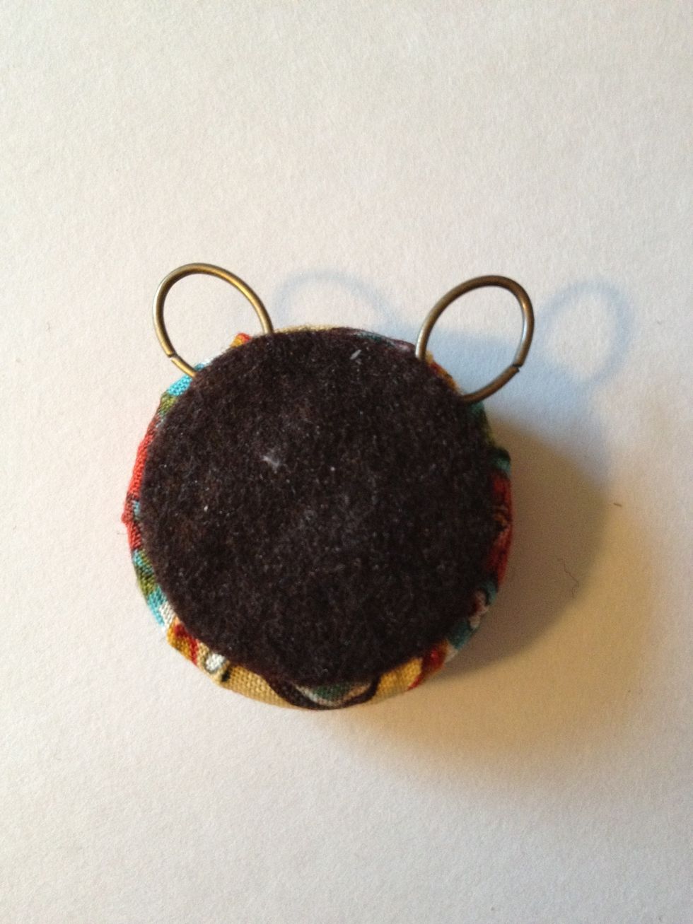 Place on back of button, being sure to cover the stitches at the bottom of the jump rings.