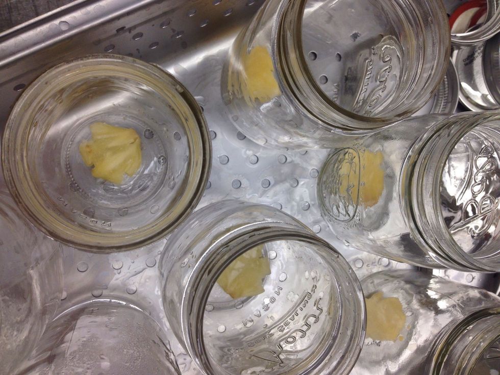 Place one clove and divided seasonings to the bottom of each sterilized jar.