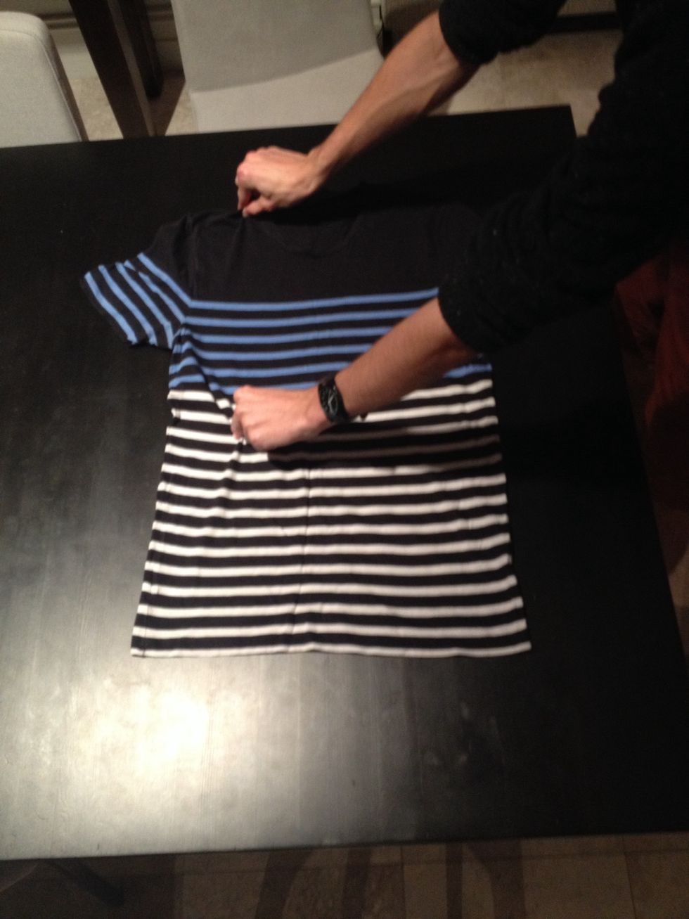 Place one hand around one third of the way from the sleeve at the top of the t-shirt, and place your other hand half way down the t-shirt but inline with your other hand