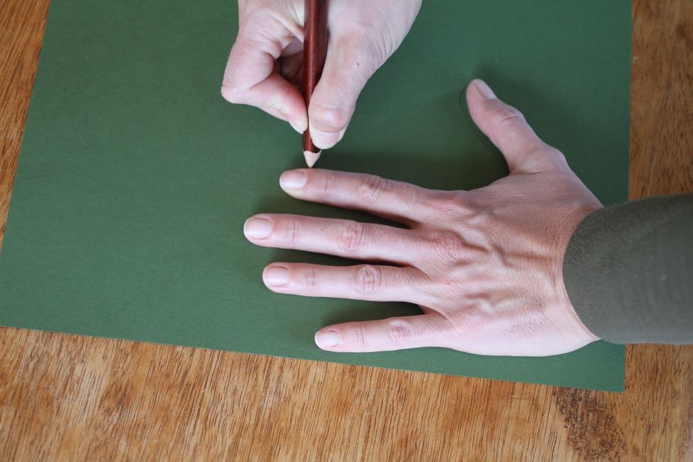Place one hand flat on a piece of green paper and trace it with your pencil.