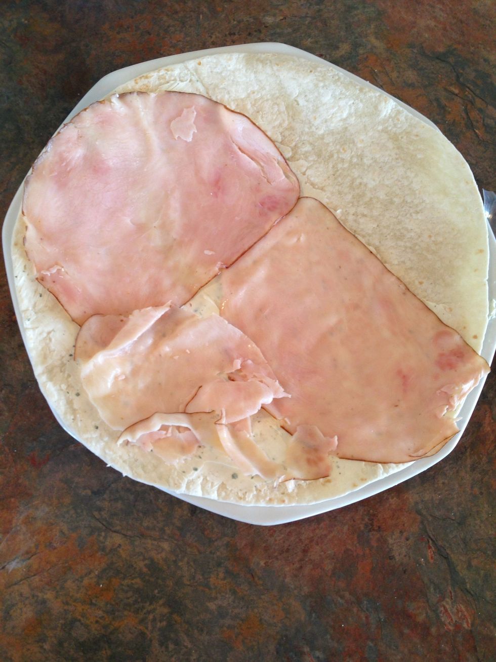 Place one layer of turkey on top of the part of the tortilla with the cream cheese/ranch mix on it.