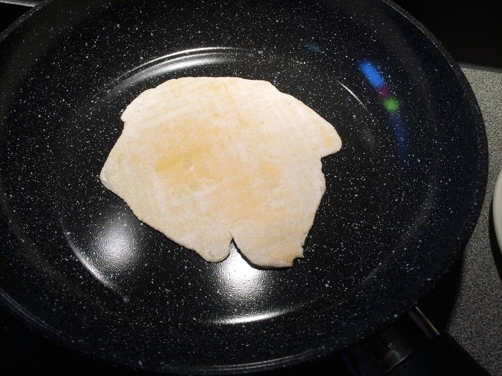 Place one of the tortillas on to the pan and cook for 2 minutes on each side.
