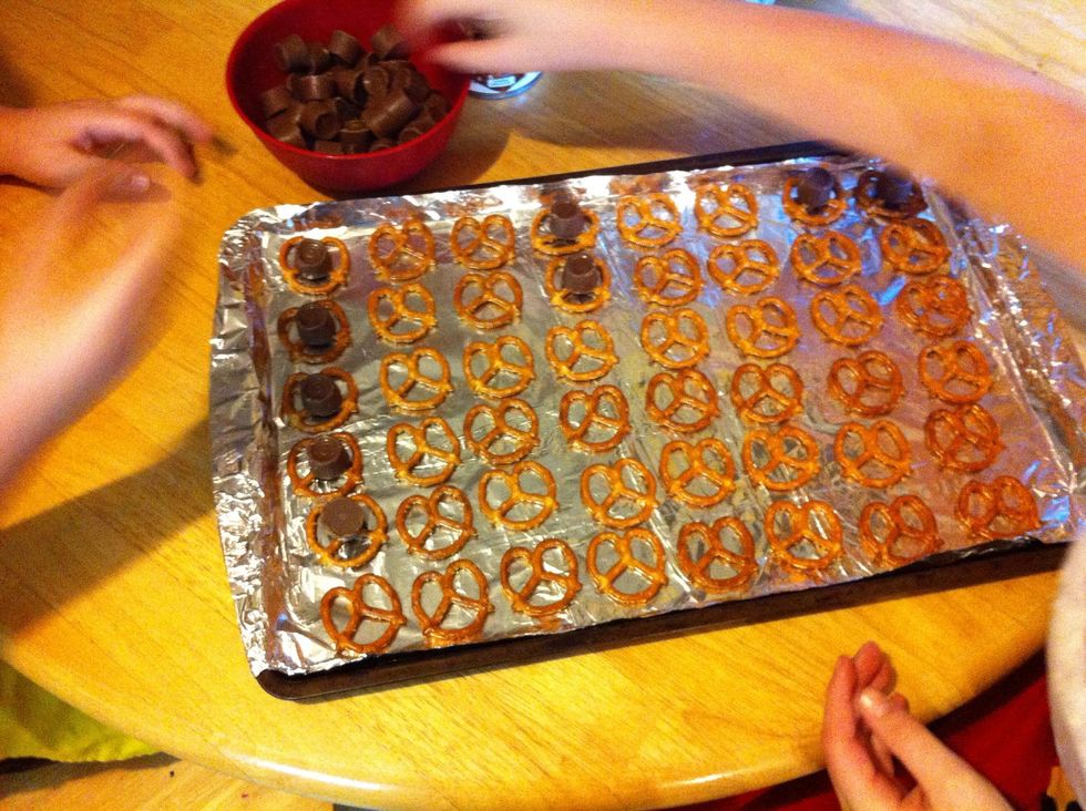 Place one Rolo on each pretzel.