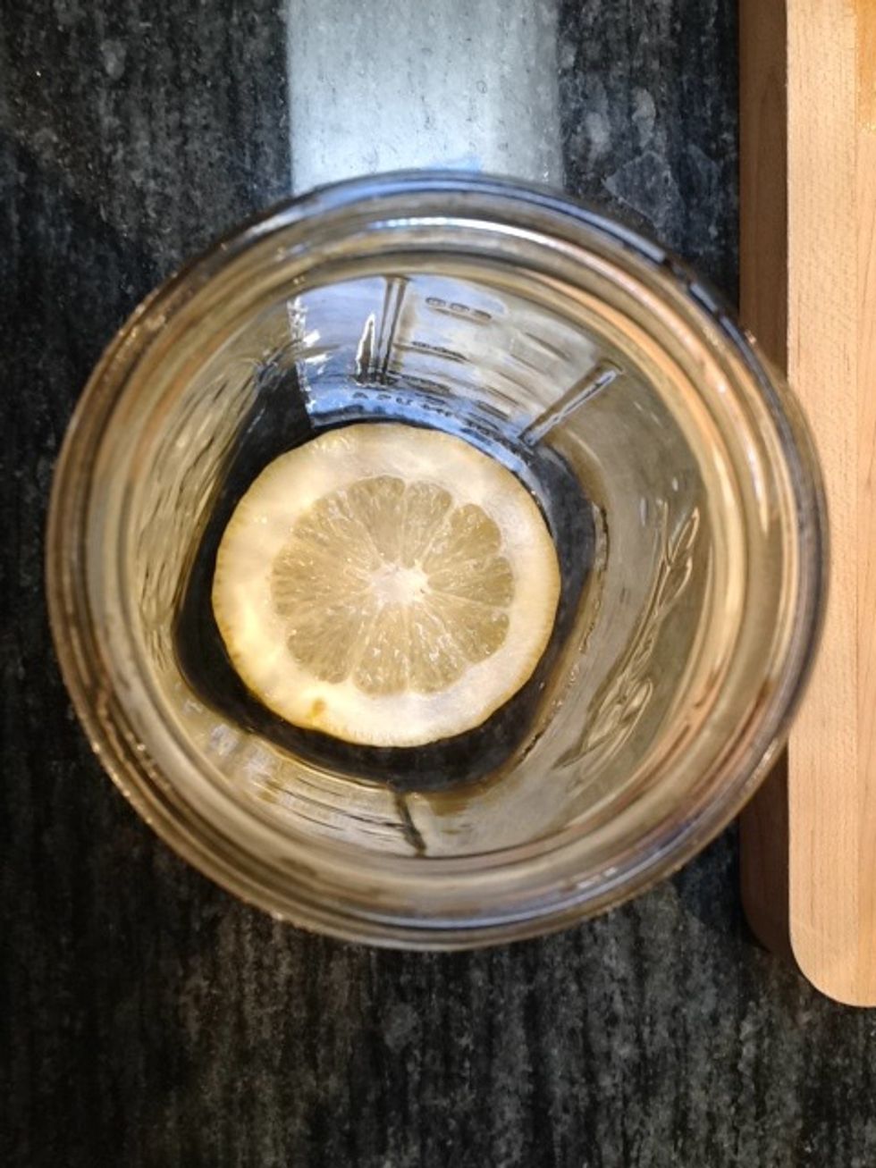 Place one slice of lemon in the bottom of each quart jar.