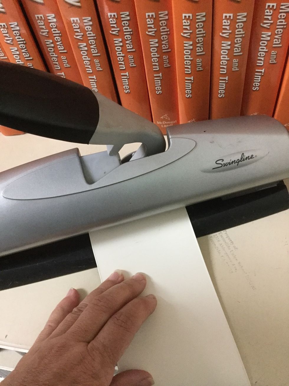 Place OPPOSITE end (with no hole) into a standard hole punch, or you can use a hand-held punch. Aim for the middle of the blind and press gently.