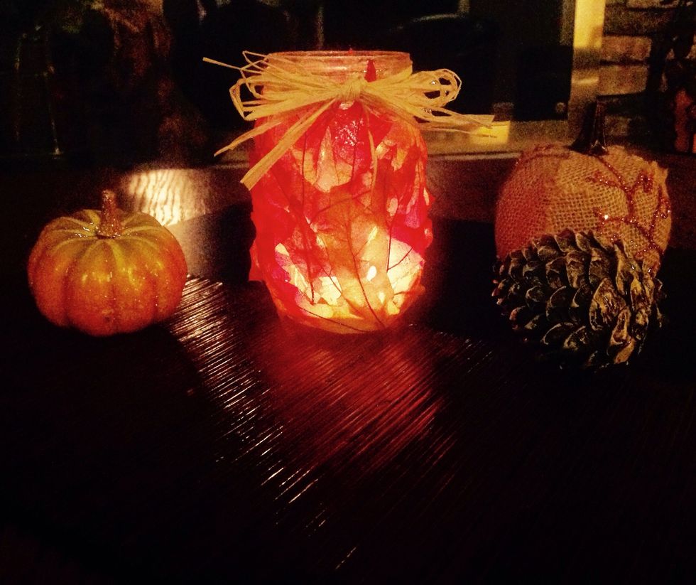 Place other fall items such as pumpkins and pine cones around the jar for extra decoration.