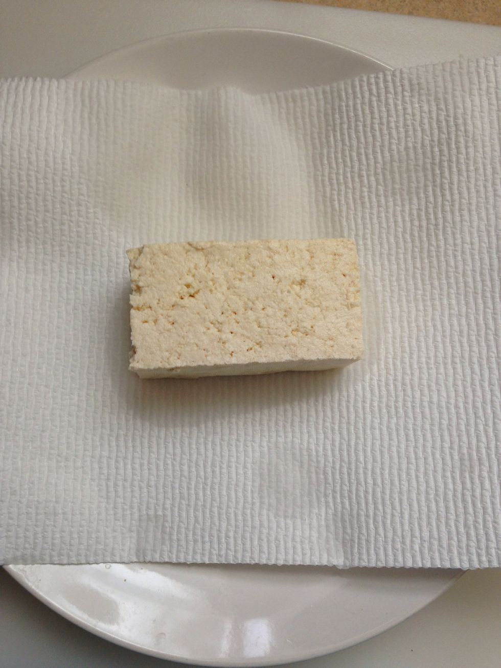 Place paper towel on plate and place the tofu block to drain excess water
