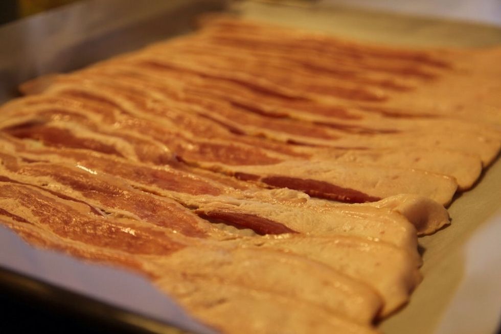 Place parchment paper on a baking pan and lay bacon flat.