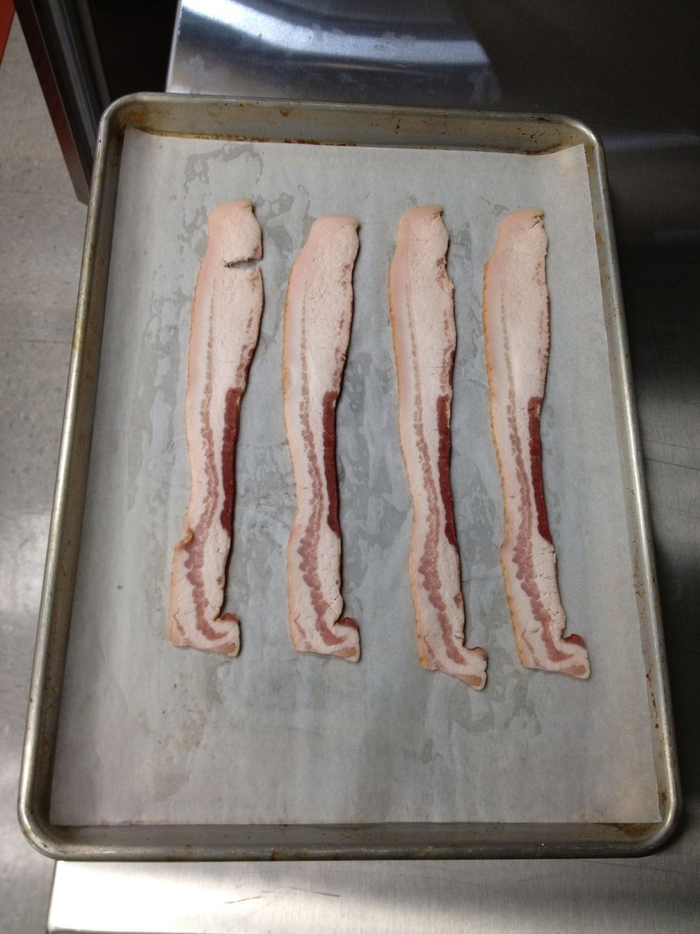 Place parchment paper on sheet pan and lay the bacon on top of the parchment paper.