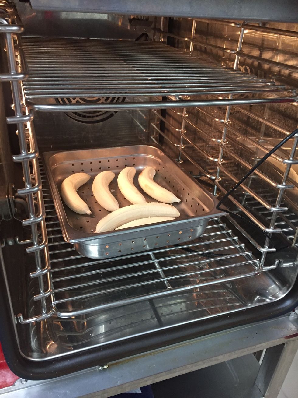 Place peeled bananas, excluding one, into a perforated pan.