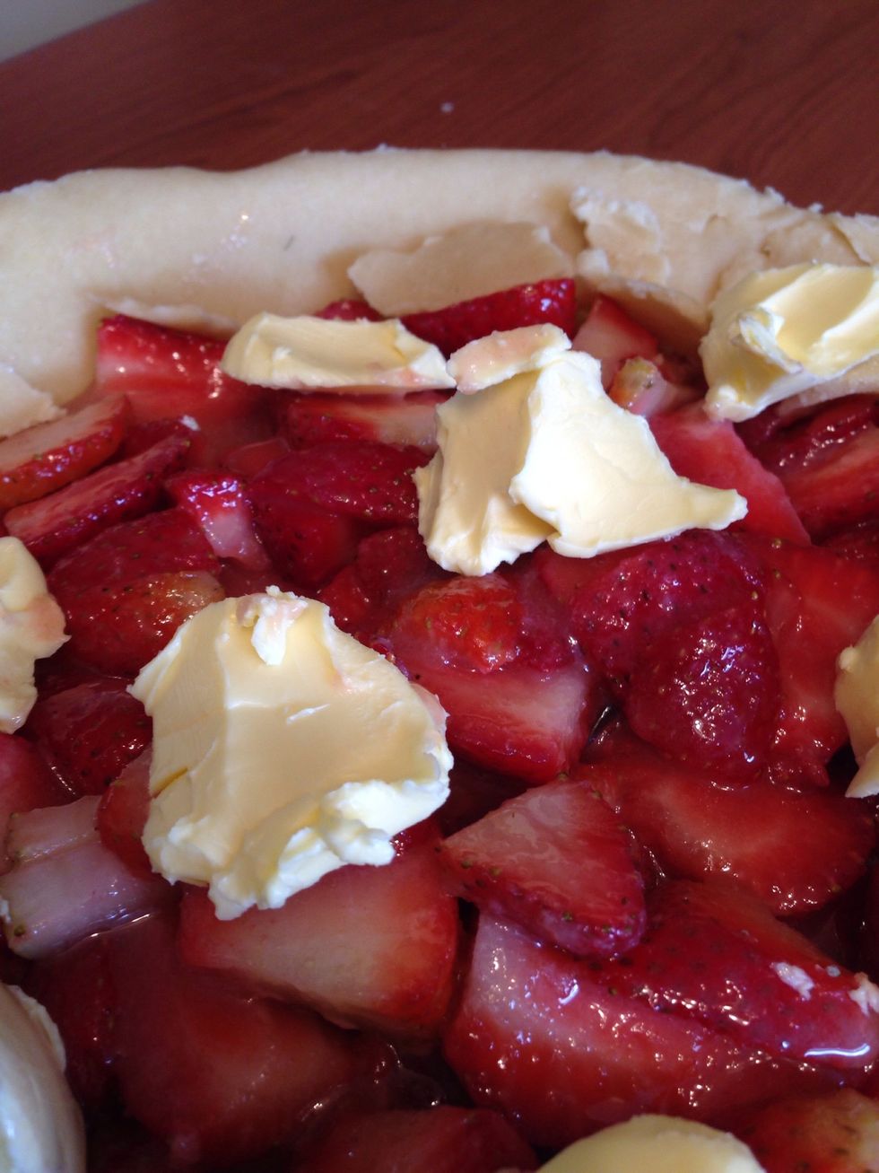 Place pieces of butter on top of strawberries.