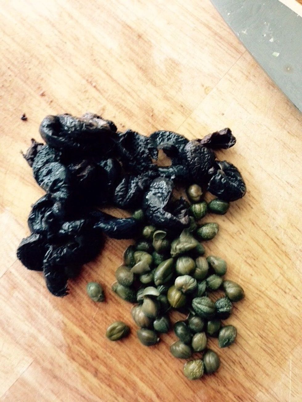 Place pitted olives and capers on a cutting board