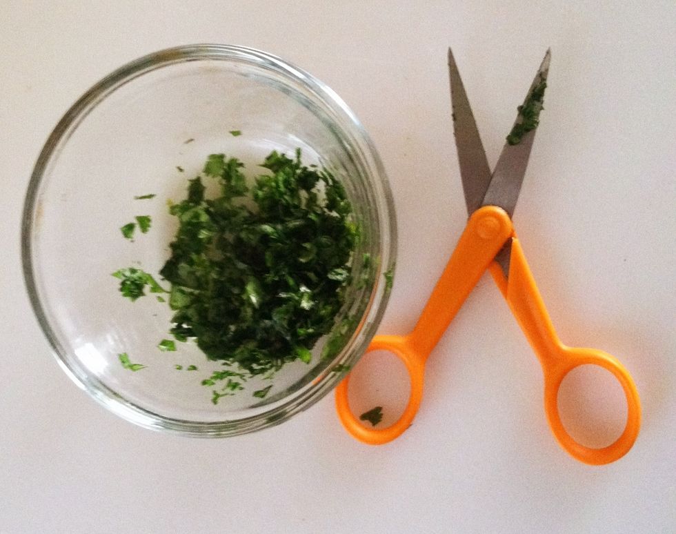 Place portion of cilantro that needed into a glass bowl and continue snipping finely.
