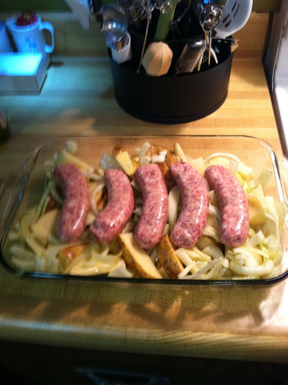 Place (raw) sausage on top of potatoes and onions in baking dish.