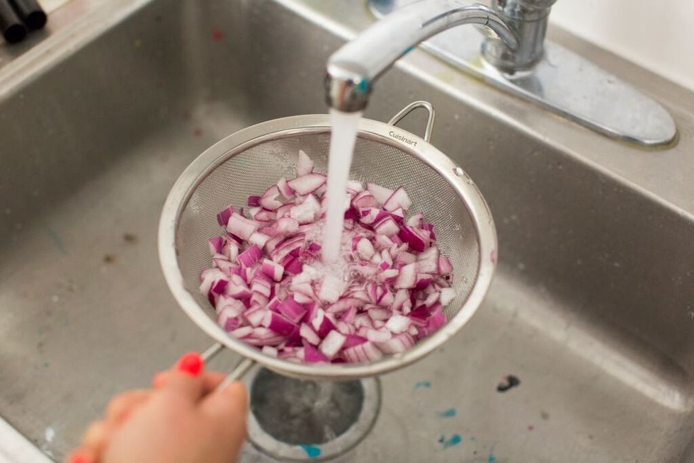 Place red onion in sieve and rinse under cool water to remove bite. Drain well and then place in bowl.