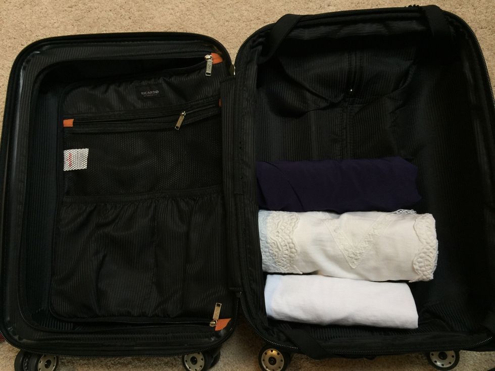 Place rolled items in the bottom of the suitcase.