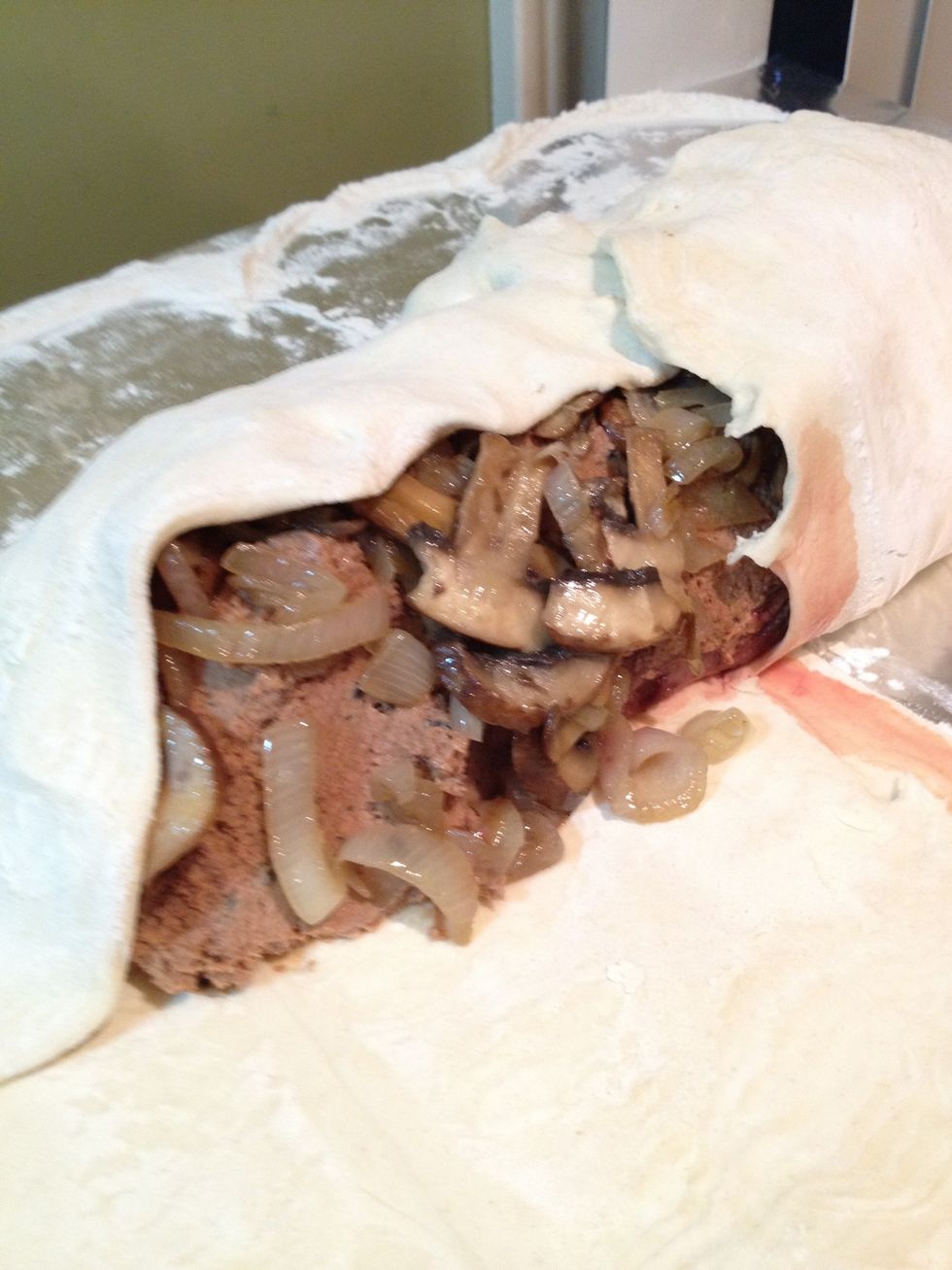 Place saut\u00e9ed mushrooms and onion over the pate and beef. Wrap the puffed pastry around the whole thing.
