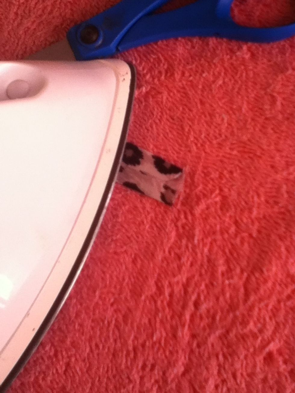 Place scissors on one end of the piece of folded fabric to weigh it down and iron the piece.