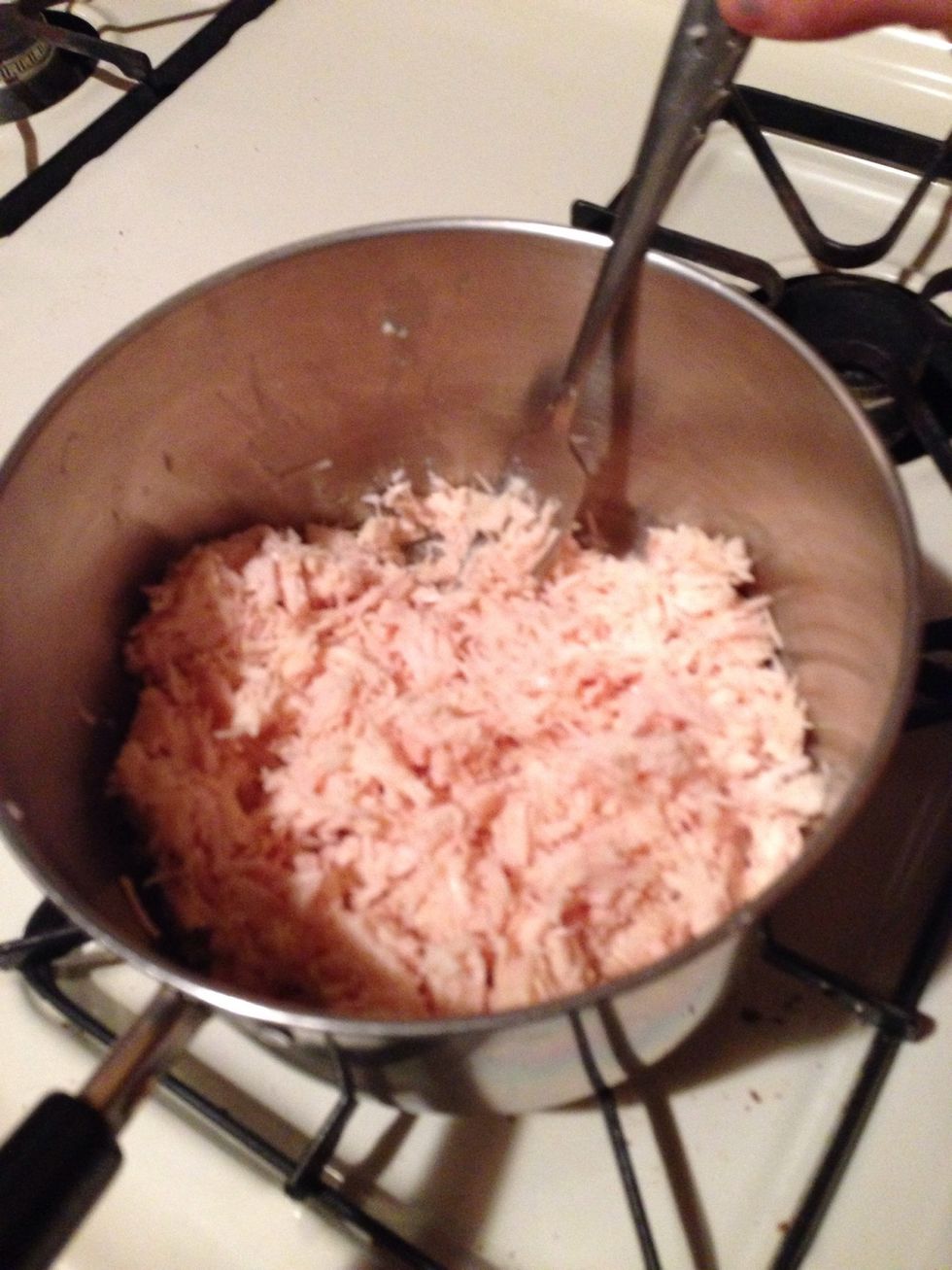 Place shredded chicken into pan on the stove.