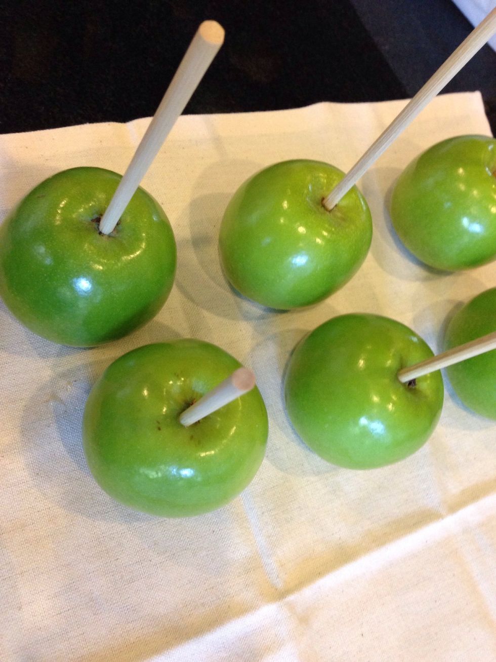 Place skewers in apples. You may have to use a little force. If your skewers are too short make sure it doesn't go down too far-you don't want to burn your hand while dipping.
