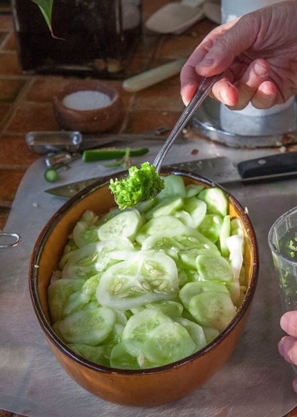Place sliced dried cucumbers in a bowl. Add in the chopped green serrano chilies.