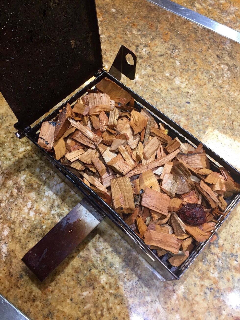 Place soaked wood chips into the smoker box and attach to the oven.