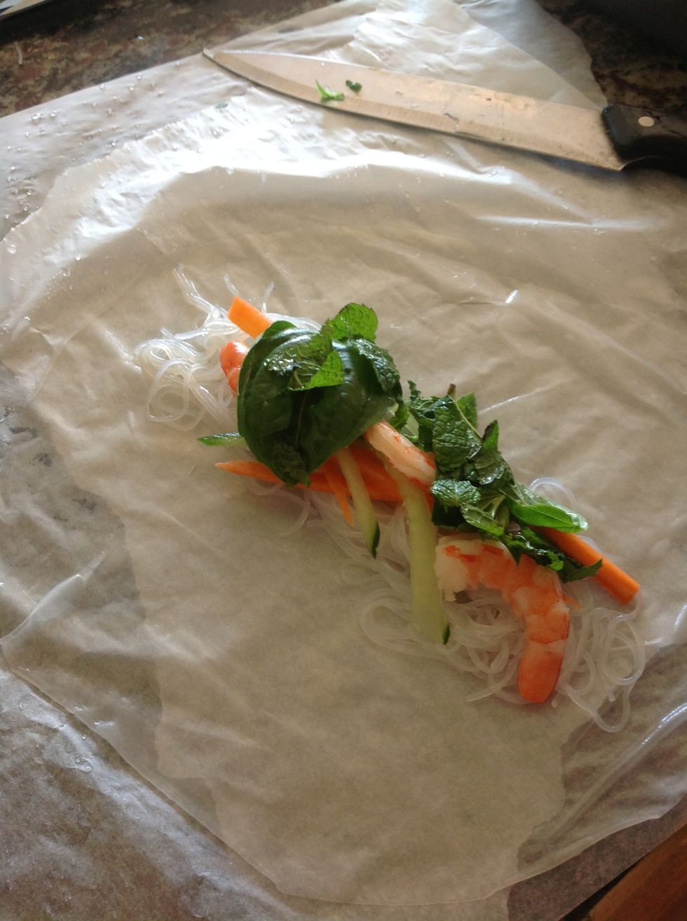 Place softened rice paper on wax paper and place ingredients in the middle. Fold it like a burrito (any two opposite sides are folded in, third side folds over, and last side folds on top the roll).