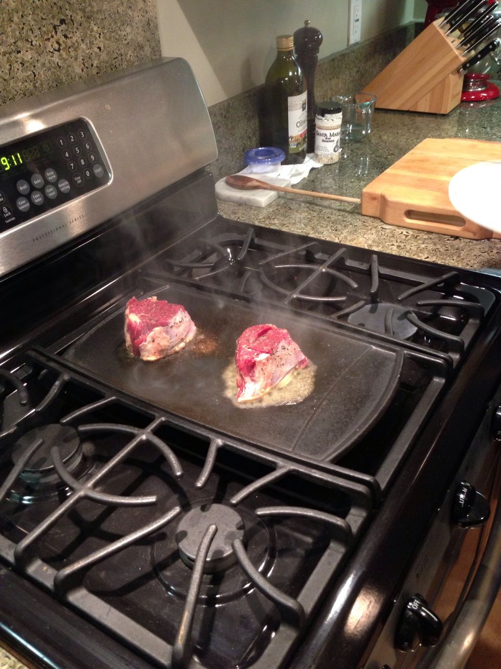 Place steak in plate of butter briefly, one side only and then place on cooking surface, butter side down. Cook over very high heat for 2-4 minutes depending on thickness. Do not move the steak.