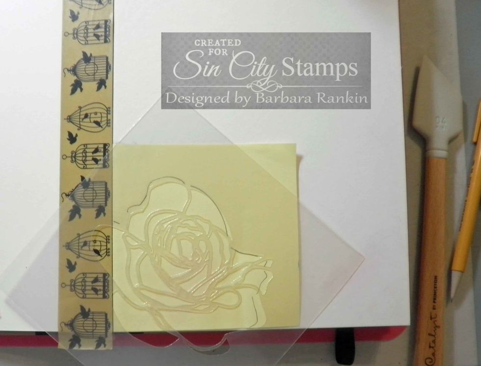 Place strip of washi tape along left edge of cover page. Lay post-it note along edge, trace rose stencil edge and cut out to make a mask.