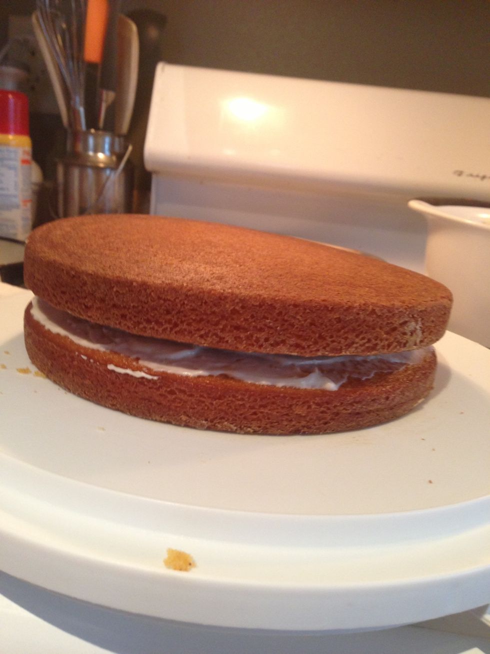 Place the 2nd layer of cake, upside down, on top of the 1st frosted layer of cake.