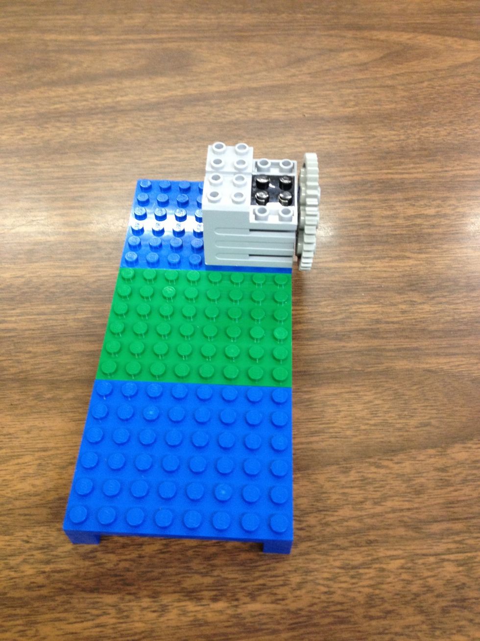 Place the 40 tooth gear on the 9V motor and then place the motor on the small thin plates.