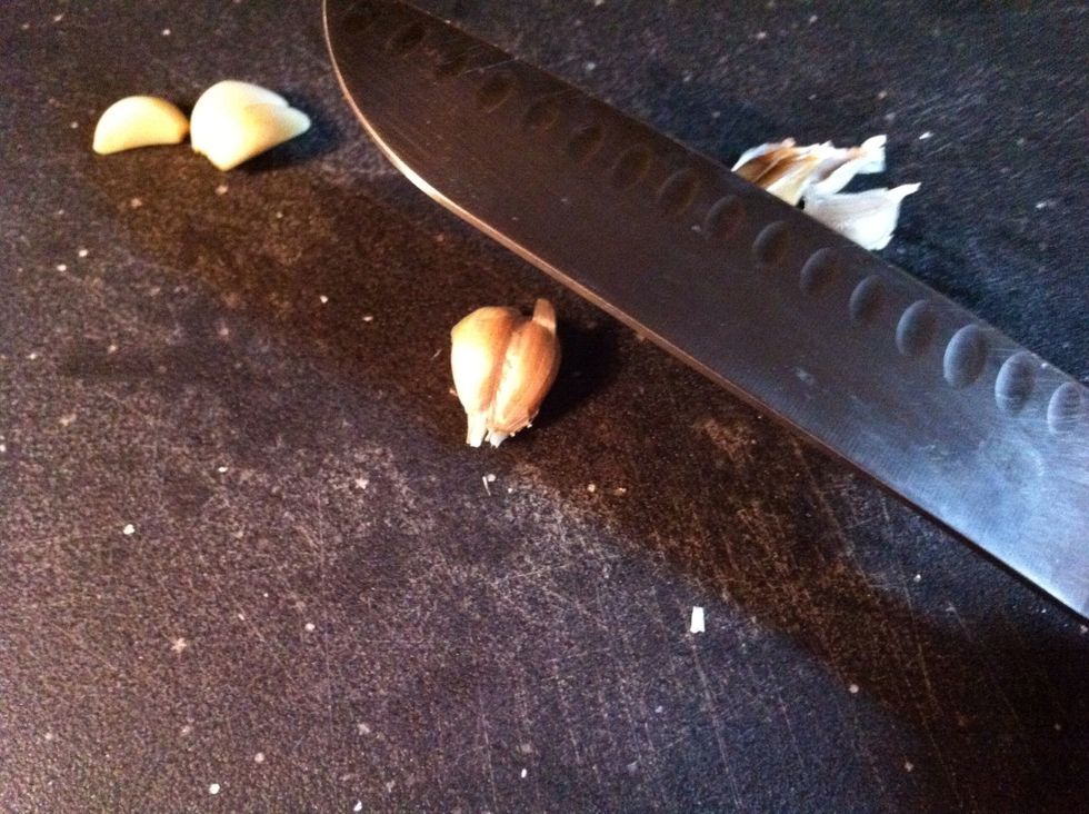 Place the back of knife on the clove.
