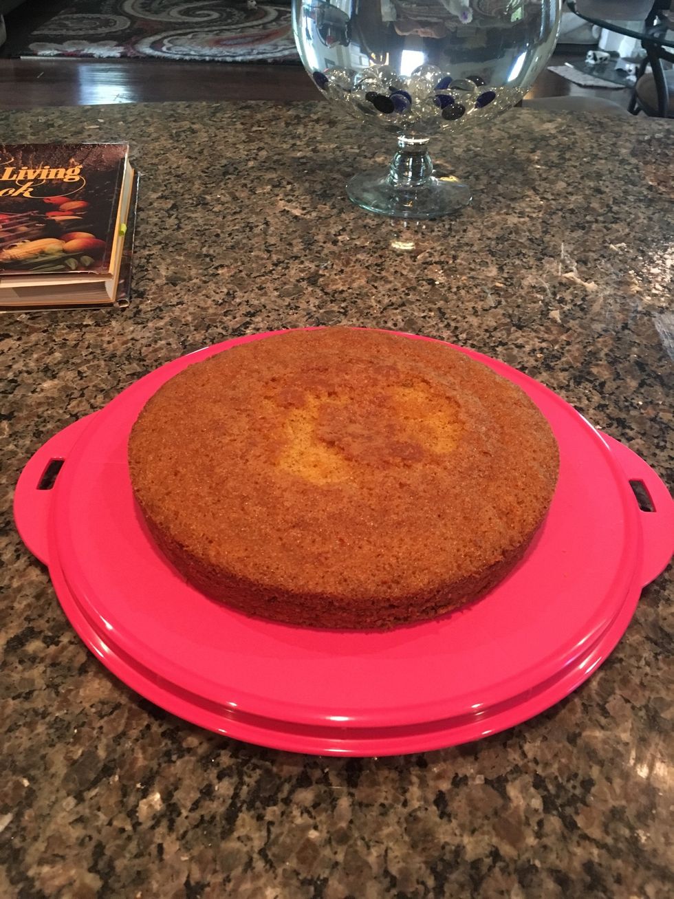 Place the base layer of the cake onto a cake container base.