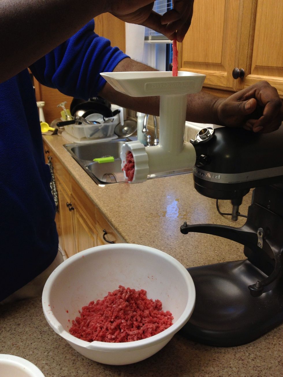 Place the beef strips in the grinder one at a time. This helps the grinder not get clogged. U can place some plastic wrap over the grinder spout to help keep the mess contained. Don't forget the bowl!