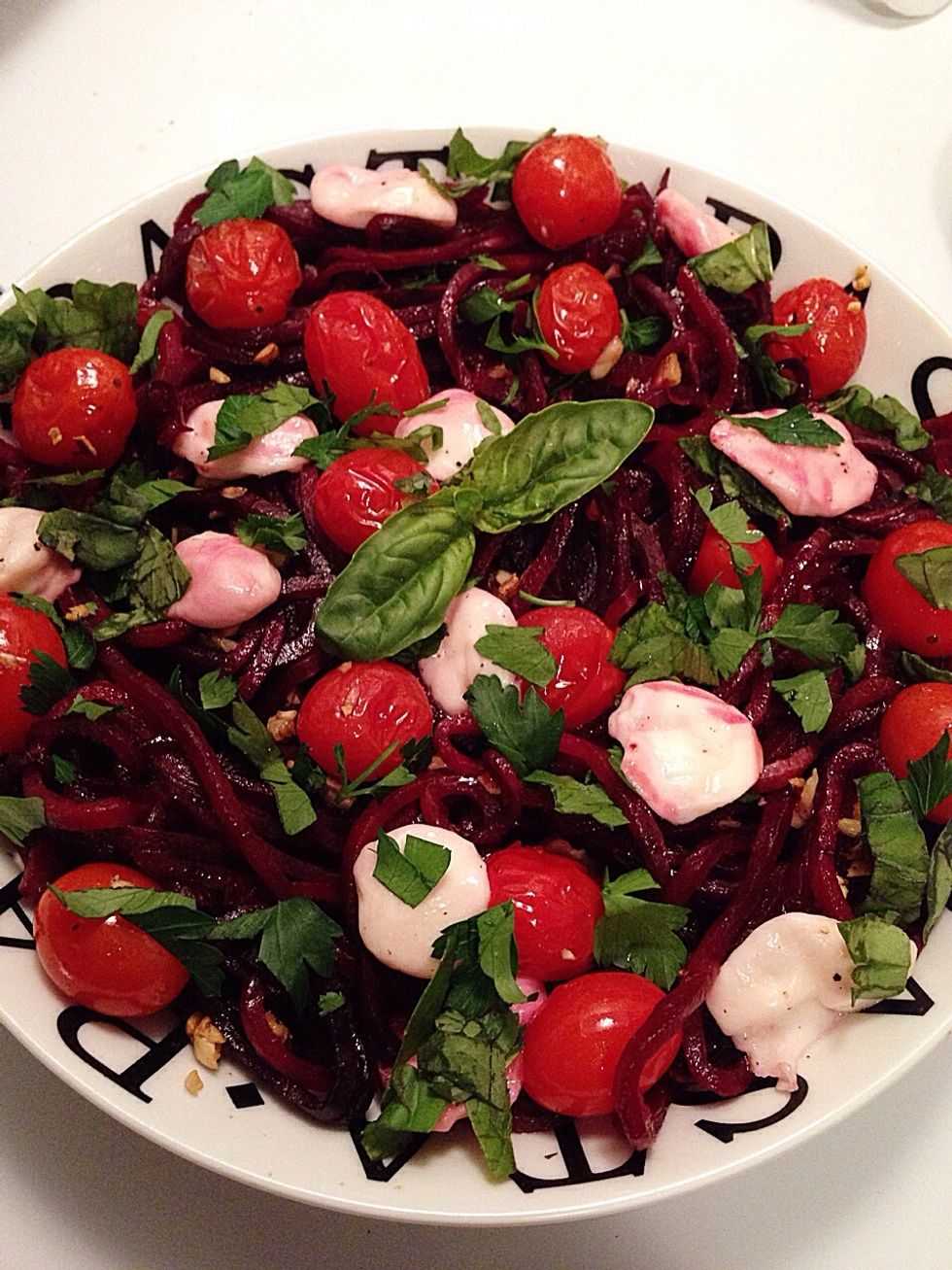 Place the beet noodles in a bowl and top with the melted mozzarella, garlic roasted tomatoes, & some fresh parsley & basil. Enjoy!