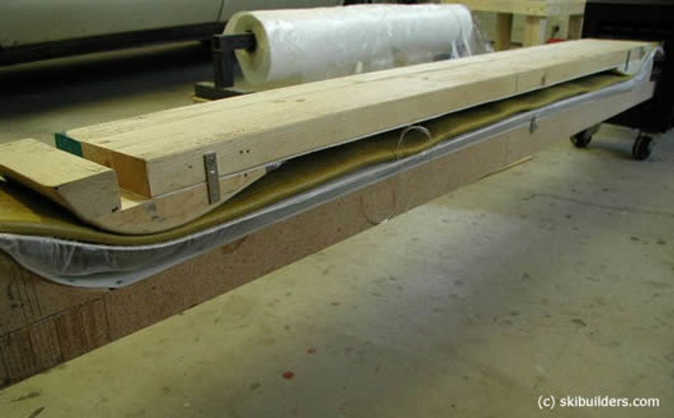 Place the bladder on top of the ski and then place the top of the mold on the bladder