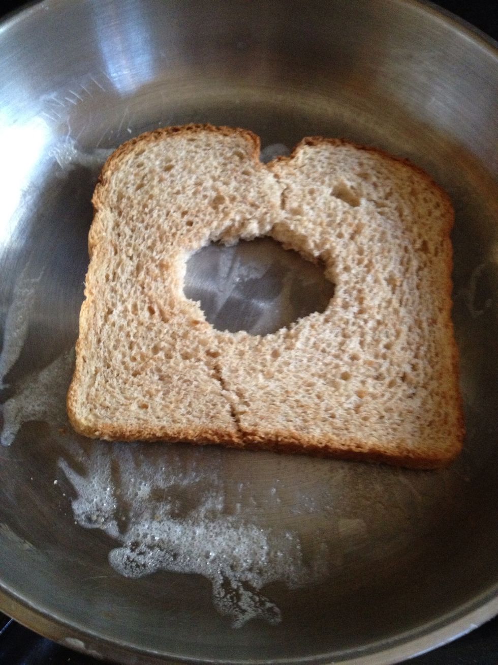 Place the bread on a hot saut\u00e9 pan greased with Pam or butter. (Try to place the bread with the crack facing up so when you flip it over it will be less likely to split in half)