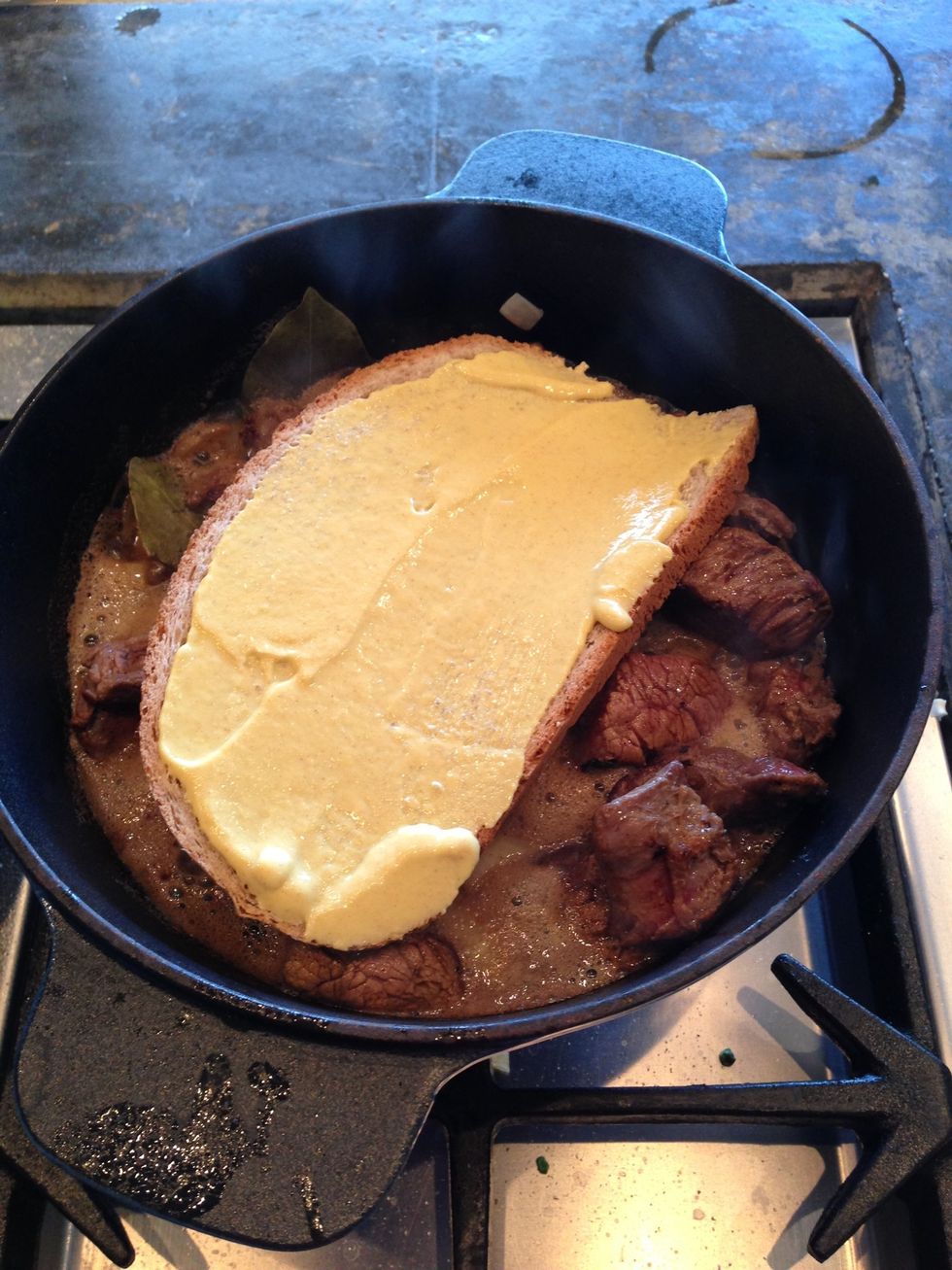 Place the bread with mustard on top of the meat.