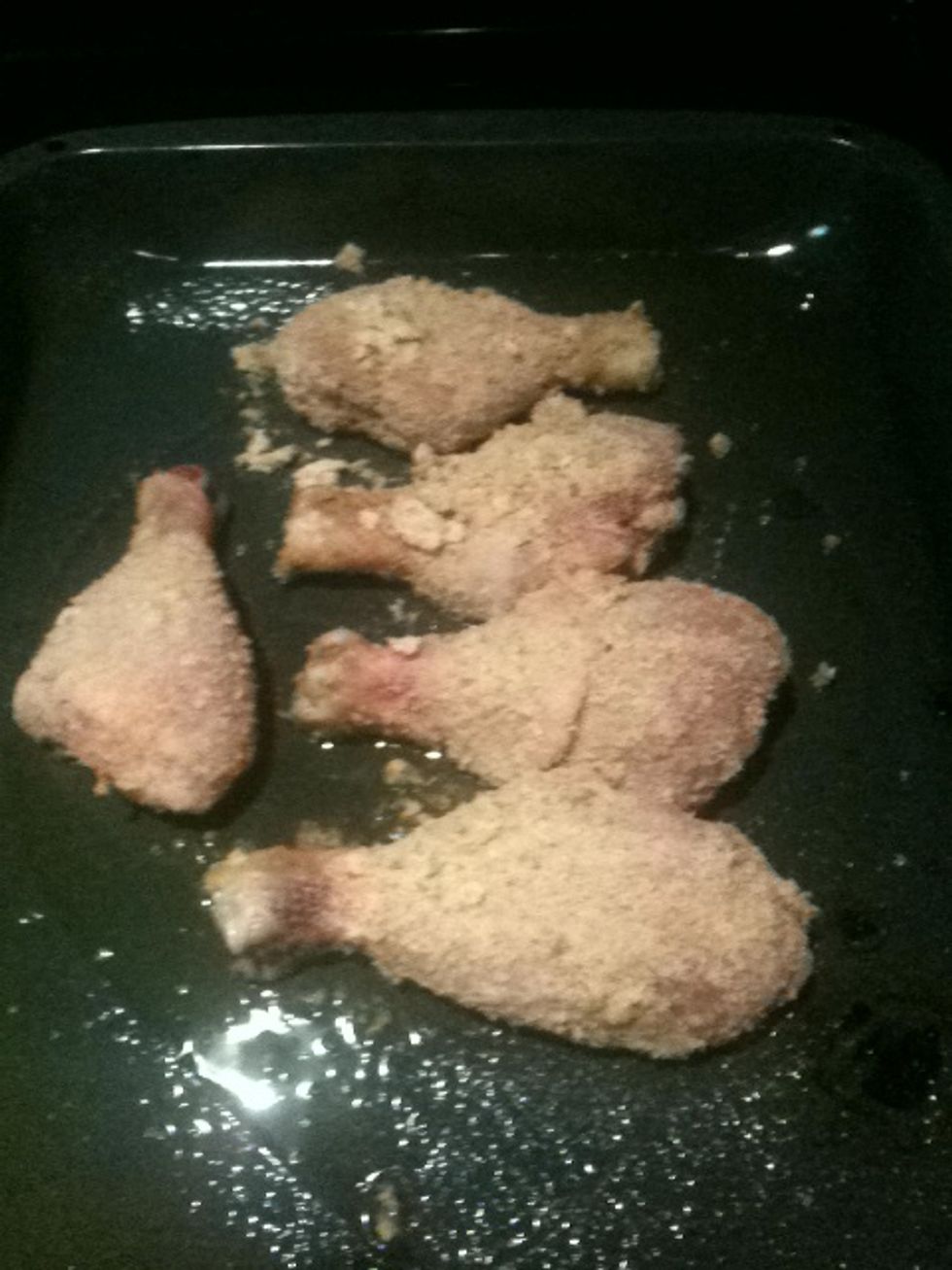 Place the breaded drumsticks in the baking pan.