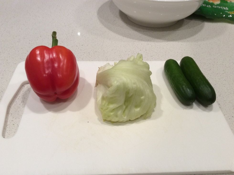 Place the capsicum, iceberg lettuce and baby cucumber on the chopping board