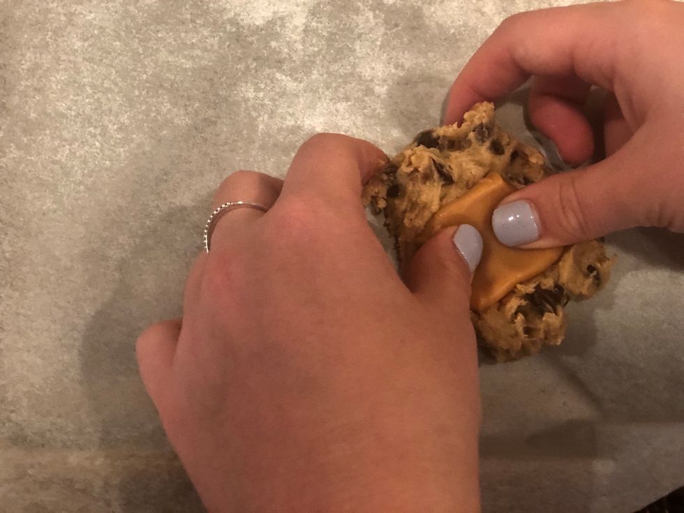 Place the caramel in the dough and wrap the dough around the caramel