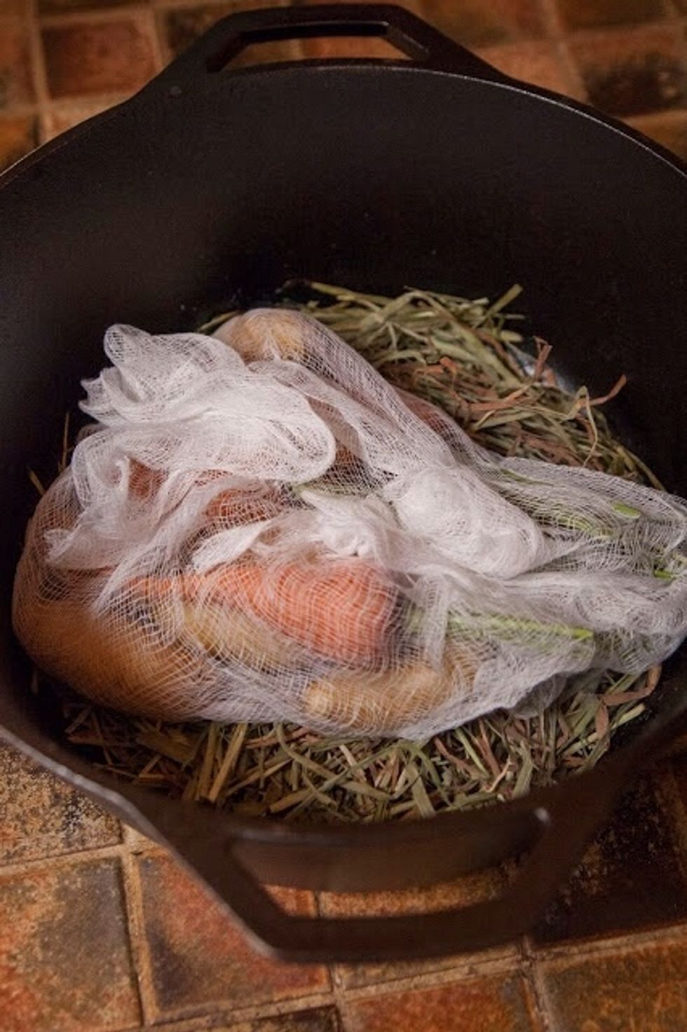 Place the cheesecloth bundle on top of the hay in the pot.