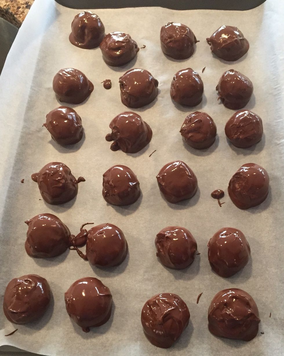 Place the chocolate covered dough balls on a sheet of wax paper. Repeat with the rest of the dough balls.