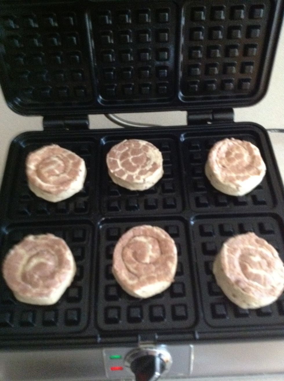Place the cinnamon rolls into the waffle maker. Close the lid and press down slightly.