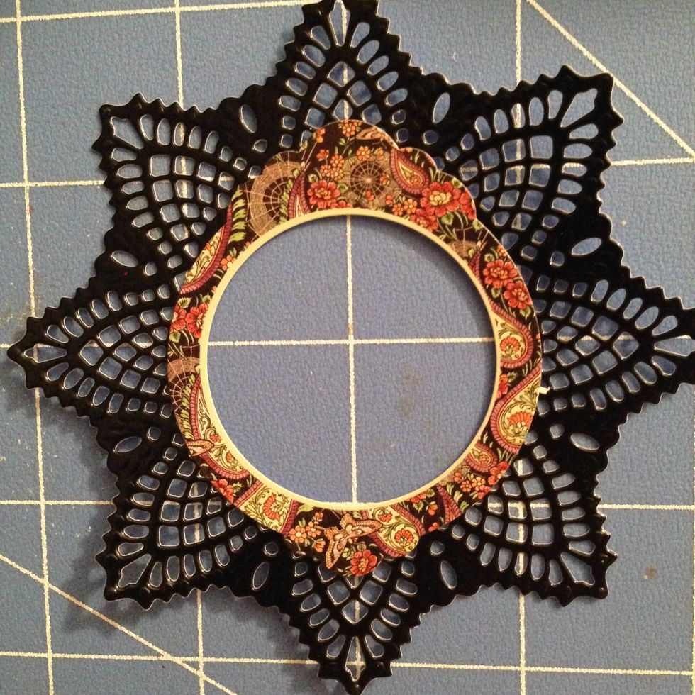 Place the circular sticker on top of the black doily.