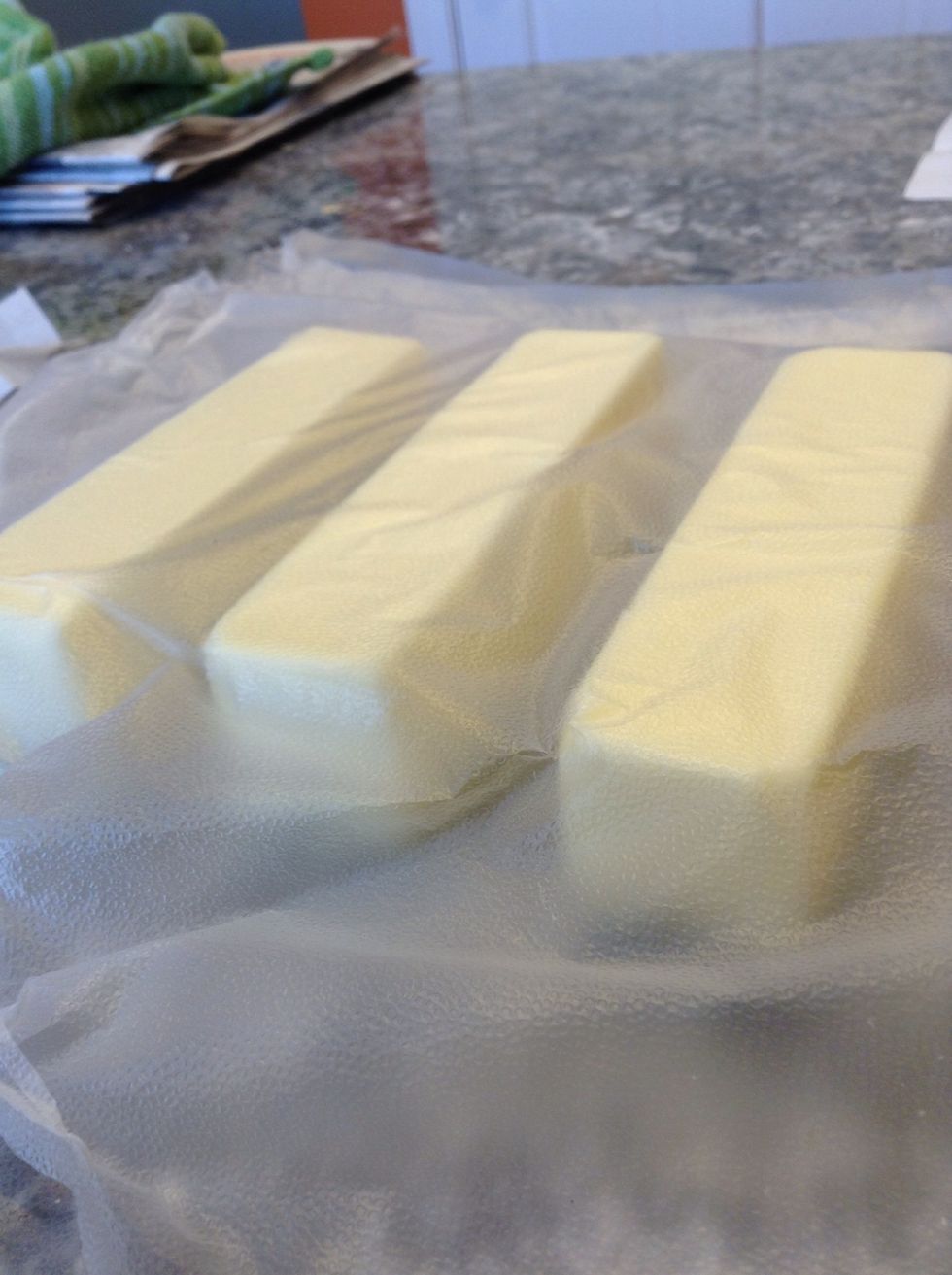 Place the cold butter in between two pieces of plastic wrap. Use a rolling pin to pound out the butter into an 8 inch square. Measure it with a ruler