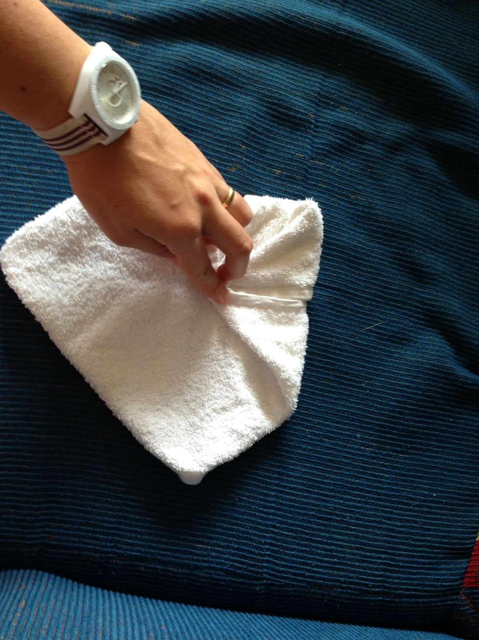 Place the corners of the towel to the center of it forming a square...