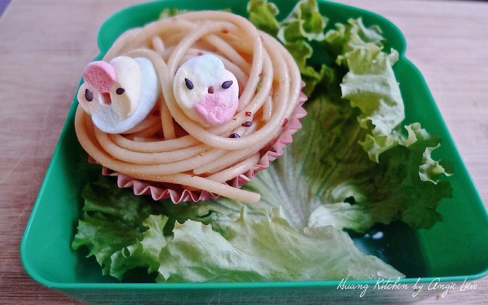 Place the cupcake liner piled with the spaghetti and " cute baby birds" on the lined lettuce in the lunchbox.