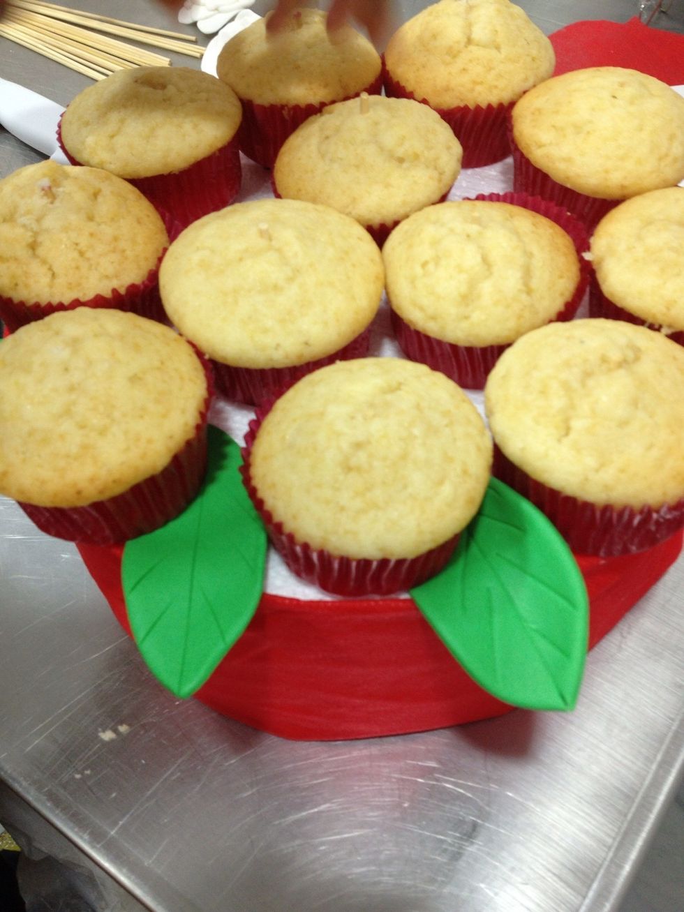 Place the cupcakes on the decorated board and stick the skewer through them.